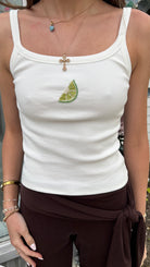 Person wearing a white tank top with a beaded lime design. Summer tank top 