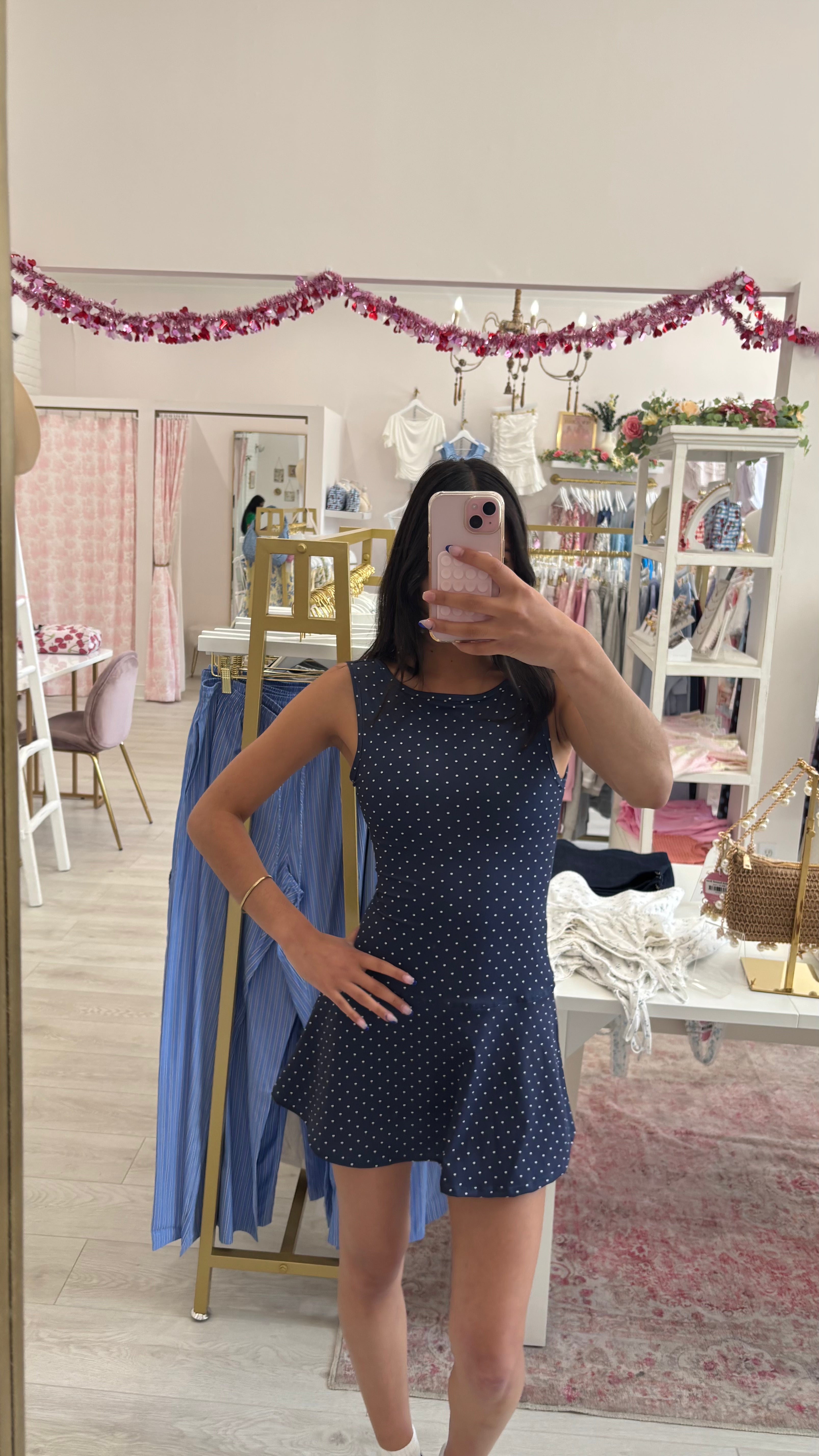 Person wearing a navy blue polka dot dress.  athletic dress for summer